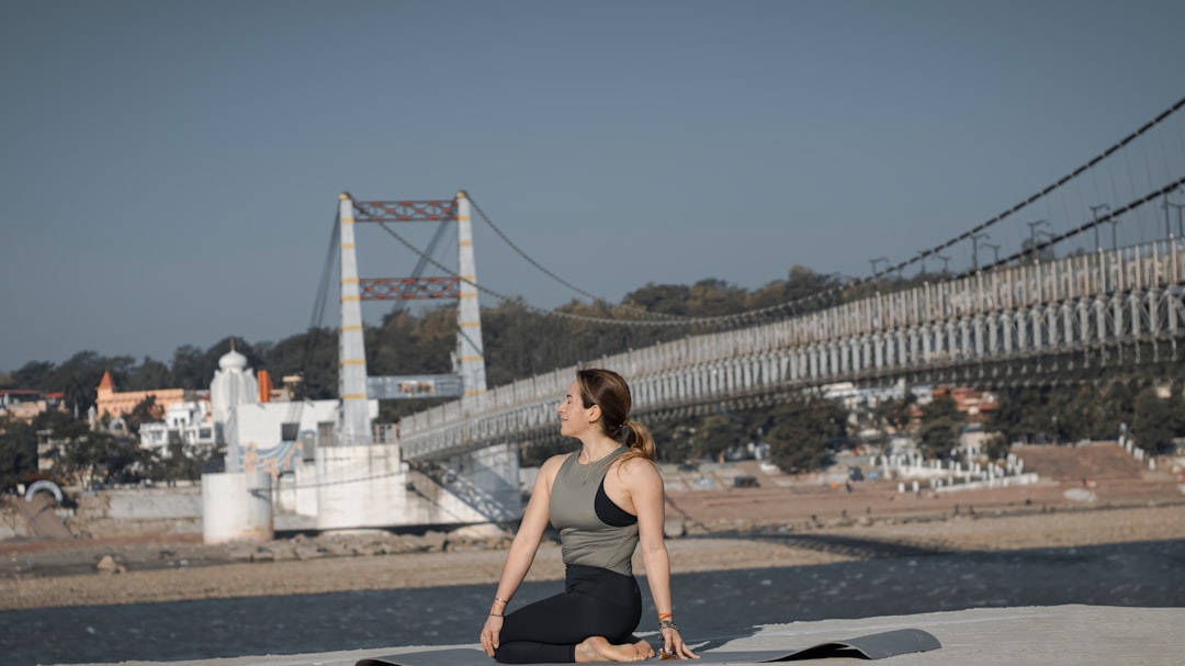 Offerings a-woman-sitting-on-a-yoga-mat-in-front-of-a-bridge-e2tr0qleq3u